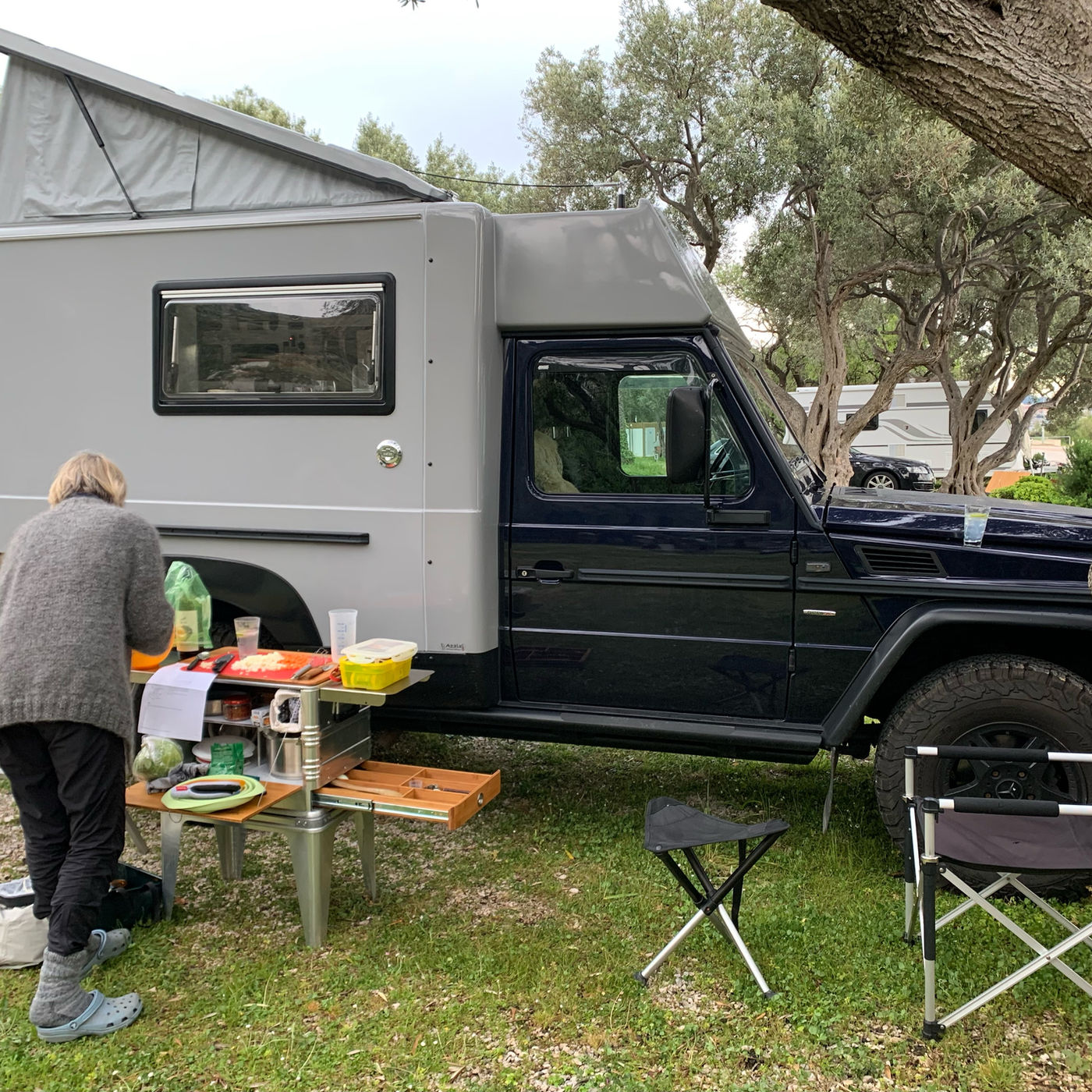 Owner cooking on a DOCK kitchen beside a Mercedes G-class camper in Croatia